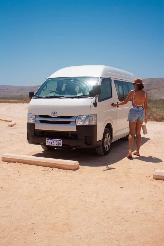 Woman standing outside van on the beach