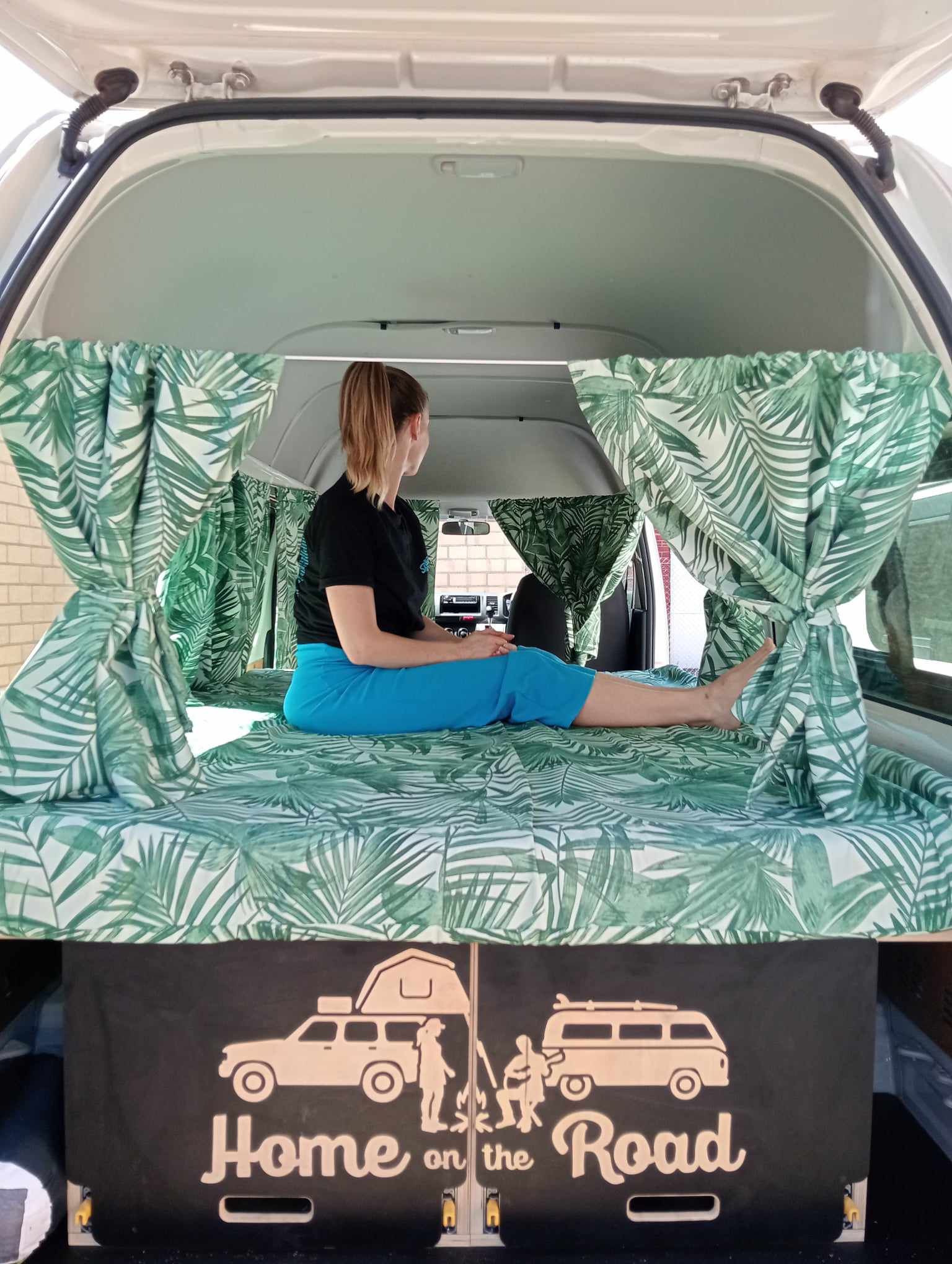 person sitting on bed inside campervan