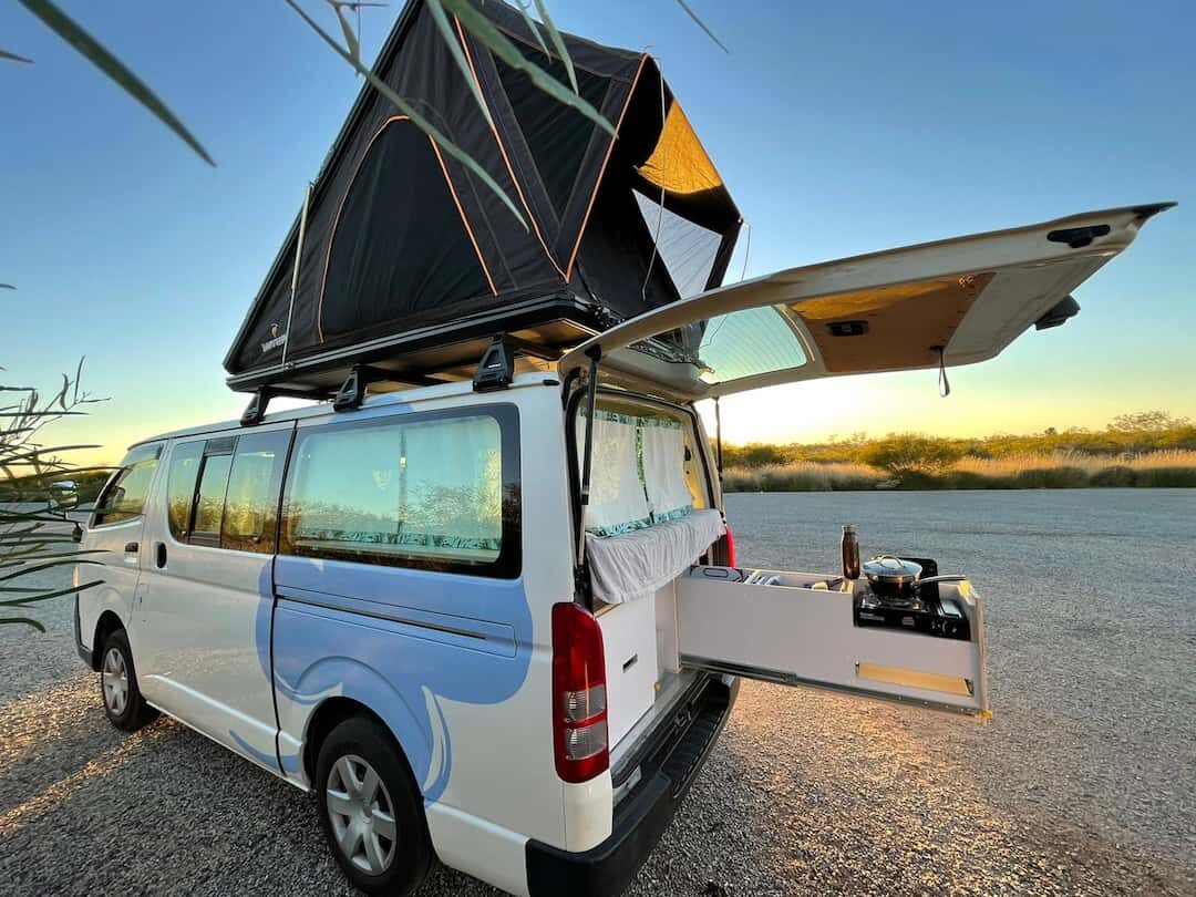 2 - 5 seater campervan opened up with rooftop tent set up during sunset as example of a good family campervan hire