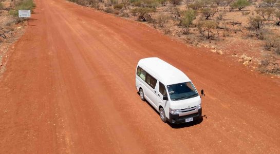 Drone shot of campervan driving in Western Australia on unsealed gravel road in the outback
