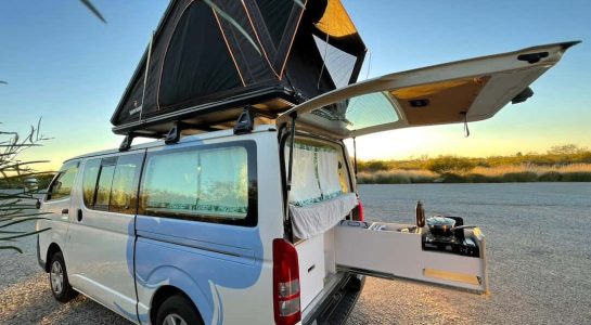 2 - 5 seater campervan opened up with rooftop tent set up during sunset as example of a good family campervan hire
